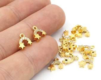 May include: Gold-toned metal charms with a crescent moon and star design, adorned with clear rhinestones. The charms have a loop for attaching to jewelry or other crafts.