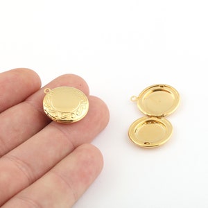 May include: Two gold-tone locket pendants. One locket is closed and the other is open, revealing the empty interior. Both lockets have a decorative design.