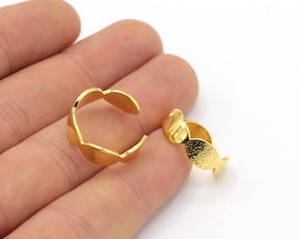 May include: Two gold-toned metal rings with a textured finish. The rings are open and can be adjusted to fit different finger sizes.