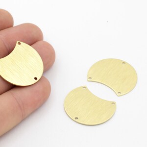 May include: Three gold-toned metal half-circle shapes with a brushed finish and two holes each. The half-circles are approximately 1.5 inches in diameter.