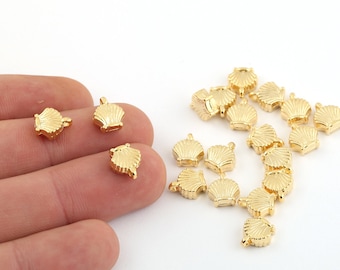 May include: A group of gold-colored metal seashell charms. The charms are small and have a detailed design. They are perfect for adding a touch of nautical style to jewelry or crafts.