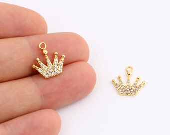 May include: Two gold-tone crown charms with clear crystal embellishments. The charms have a loop at the top for attaching to jewelry.