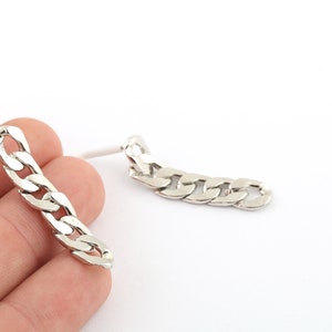 May include: A pair of silver chain earrings with a curb link design.