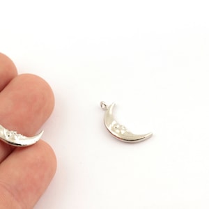 Puede incluir: Dos abalorios de plata en forma de media luna con un diseño de cara. Los abalorios tienen un bucle en la parte superior para sujetarlos a joyas.