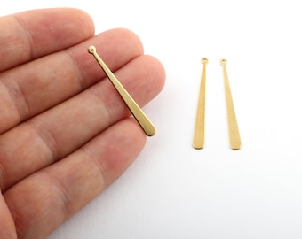 Könnte beinhalten: Drei goldfarbene Metall-Ohrring-Findings mit einer Öse oben und einem spitzen Ende. Die Findings sind etwa 3,8 cm lang.
