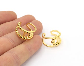 May include: Two gold-toned ear cuffs with a beaded design. The cuffs are open and adjustable to fit different ear sizes.