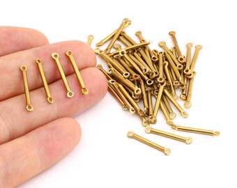 May include: A pile of gold-colored metal connector bars with loops on each end. The bars are about 1 inch long.