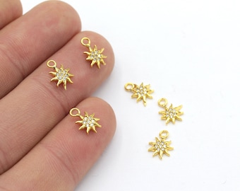 Può includere: Sei ciondoli a forma di sole dorati con accenti di cristallo trasparente. Ogni ciondolo ha un anello per attaccarlo a gioielli.