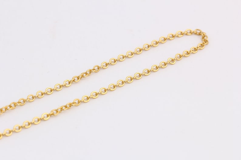 K&ouml;nnte beinhalten: Eine goldene Kettenkette mit einem zarten, runden Gliederdesign.