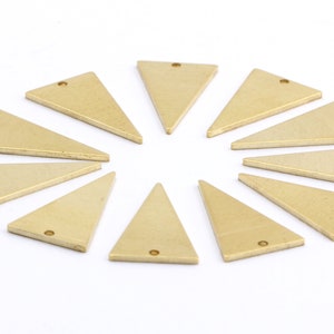 May include: Ten gold-colored triangle-shaped metal charms with a hole at the top. The charms are arranged in a circle on a white surface.