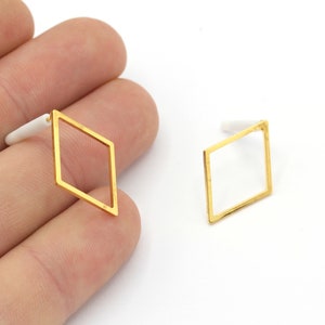 Puede incluir: Un par de pendientes de forma de diamante de color dorado con un diseño simple y minimalista.