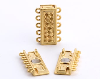 May include: Gold-toned magnetic clasp for jewelry making. The clasp has five loops on each side and a textured rectangular center piece.