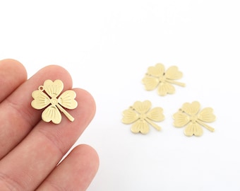 May include: Four gold-colored metal four-leaf clover charms with a textured surface. The charms have a hole at the top for attaching to jewelry or other crafts.