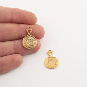 May include: Gold-colored wave pendant charms. Each charm features a circular design with a wave pattern and a triangle-shaped bail. The charms are small, ideal for jewelry making, and have a shiny finish.