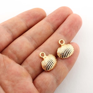 May include: Two gold-colored seashell charms with a loop for attaching to jewelry or other crafts.