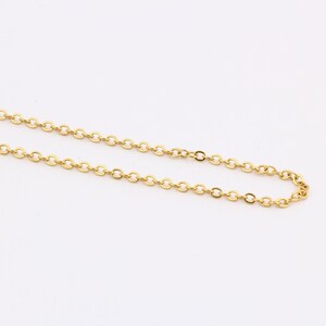 K&ouml;nnte beinhalten: Eine goldene Kettenkette mit einem zarten, runden Gliederdesign.