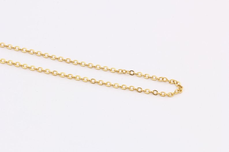 K&ouml;nnte beinhalten: Eine goldene Kettenkette mit einem zarten, runden Gliederdesign.