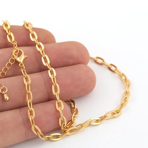 Op de afbeelding: Een gouden ketting met een karabijn sluiting. De ketting is gemaakt van ovale schakels.