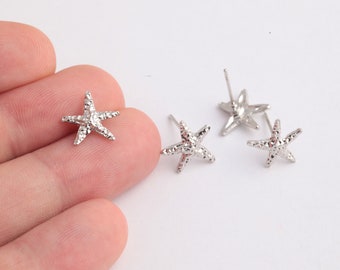 May include: Four silver starfish earrings with textured surfaces. The earrings are designed with a post and a butterfly backing.