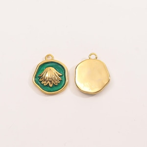以下が含まれることがあります： 2つの金色の貝殻ペンダント。1つのペンダントは、緑色のエナメル背景に金色の貝殻のデザインが施されています。もう1つのペンダントは無垢の金です。どちらも、チェーンやその他のジュエリーに取り付けるための小さなループが上部にあります。