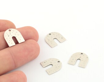 Puede incluir: Cuatro abalorios de metal plateado en forma de arco con textura martillada. Los abalorios tienen un agujero en la parte superior para sujetarlos a joyas u otras manualidades.