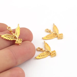 Op de afbeelding: Drie gouden metalen duivenbedels met een lus om aan sieraden of andere knutselwerkjes te bevestigen.