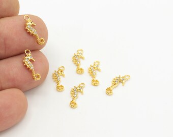 May include: Gold-tone seahorse charms with clear rhinestones. The charms have a loop at the top for attaching to jewelry or other crafts.