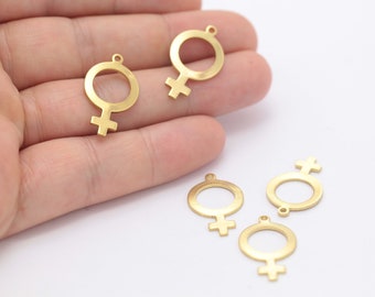 May include: Five gold-colored metal charms in the shape of the female gender symbol. The charms have a loop at the top for attaching to jewelry or other crafts.