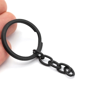 May include: A black key chain with a round metal ring and a short chain.