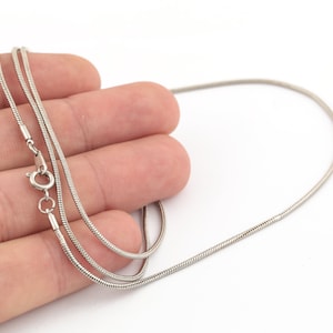 May include: A silver snake chain necklace with a lobster clasp.