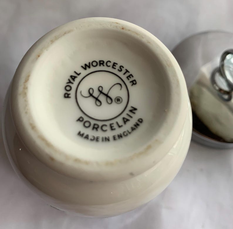 K&ouml;nnte beinhalten: Nahaufnahme einer wei&szlig;en Keramikdose mit einem schwarz-wei&szlig;en Etikett mit der Aufschrift "Royal Worcester Porcelain Made in England".