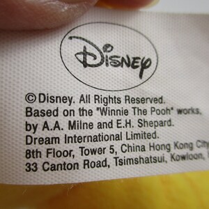 May include: White tag with black text stating "Disney. All Rights Reserved. Based on the "Winnie The Pooh" works, by A.A. Milne and E.H. Shepard. Dream International Limited. 8th Floor, Tower 5, China Hong Kong City 33 Canton Road, Tsimshatsui, Kowloon, "