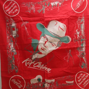 May include: Red cotton bandana with a portrait of Kit Carson, a cowboy in a hat, and the text "Drink Coca-Cola" and "Hero of the Western Frontier Plainsman, Guide, Scout Kit Carson on TV".