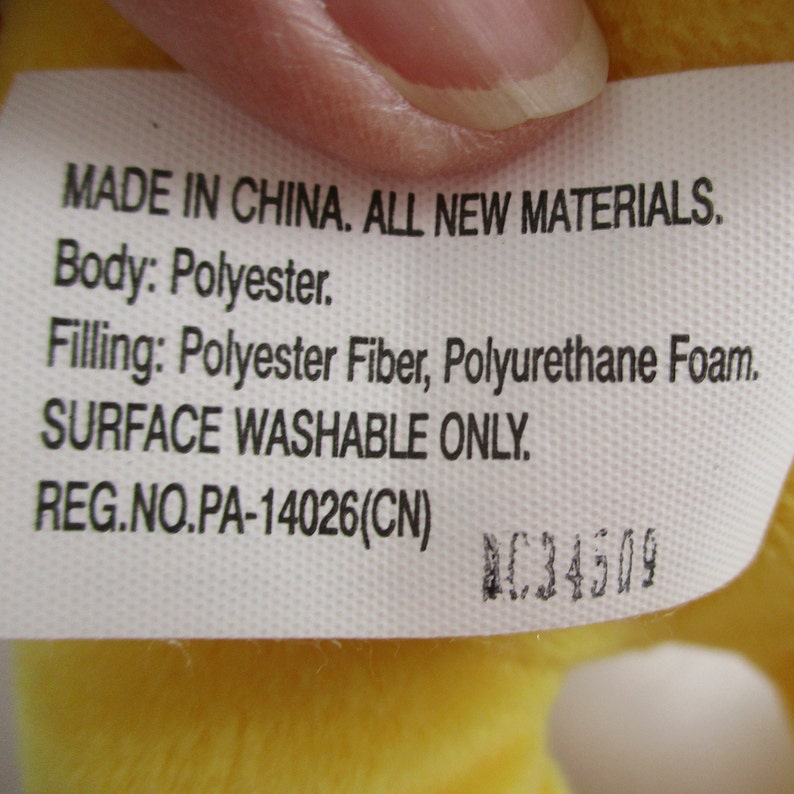 May include: A white tag with black text that reads "MADE IN CHINA. ALL NEW MATERIALS. Body: Polyester. Filling: Polyester Fiber, Polyurethane Foam. SURFACE WASHABLE ONLY. REG.NO.PA-14026(CN)" and a black number "C34509".