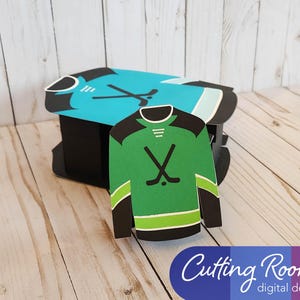 The large hockey gift box is sitting on a wood surface with the smaller gift card sized hockey jersey box propped up against it.