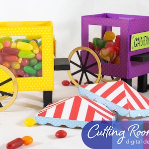 Two yellow and purple candy carts with wheels and a sign that reads 'CANDY'. The carts are filled with colorful jelly beans. Two red and white striped awnings with blue scalloped edges are on the ground in front of the carts. There are also several jelly beans scattered on the ground.