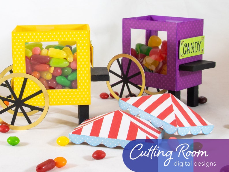 Two yellow and purple candy carts with wheels and a sign that reads 'CANDY'. The carts are filled with colorful jelly beans. Two red and white striped awnings with blue scalloped edges are on the ground in front of the carts. There are also several jelly beans scattered on the ground.