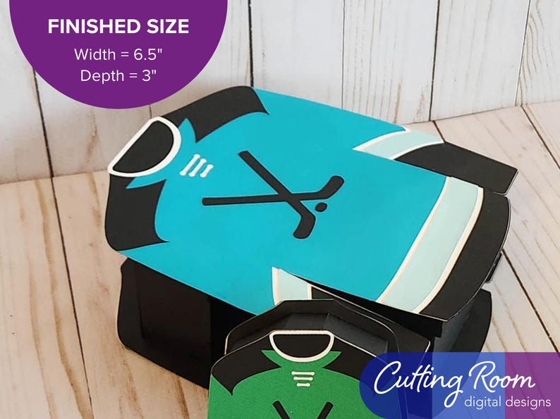 The large gift box shaped like a hockey jersey has crossed hockey sticks and a puck on the front.  There is a banner that says the box is 6.5 inches wide and 3 inches deep.