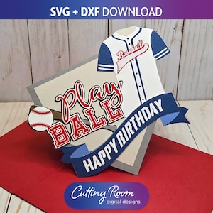 May include: A baseball-themed pop-up card with a white and blue baseball jersey, a baseball, and the words "Play Ball" and "Happy Birthday." The card is on a red surface with the text "SVG + DXF DOWNLOAD".