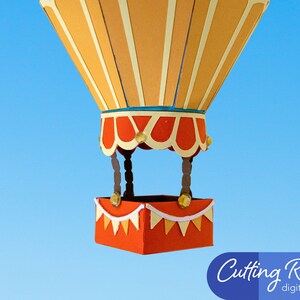 A papercraft hot air balloon with an orange basket. The balloon is made of orange and yellow paper with white stripes. The balloon is against a blue sky background.
