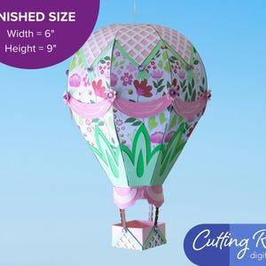 A pink paper craft hot air balloon with green and white accents.  A banner indicates that the balloon is about 6 inches wide and 9 inches tall.