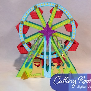 A papercraft model of a Ferris wheel with red and blue gondolas, green supports, and a purple star at the top. The model is on a green base with a gold cart and two figures standing in front of it.