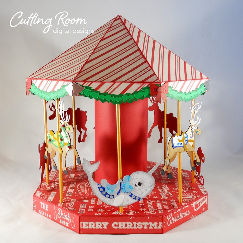 The carousel has 8 characters on the carousel, two reindeer and a narwhal are visible. The carousel is decorated with a red and white striped roof and a red base. The base has the words 'Merry Christmas' printed on it.