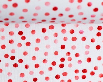 Peut inclure: Tissu blanc à pois rouges et roses. Les pois varient en taille et en nuance, créant un motif ludique et attrayant. Le tissu est plié, montrant le motif sur deux couches.