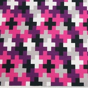 Op de afbeelding: Een stof met een geometrisch patroon met een herhalend ontwerp van plustekens in zwart, wit, roze en paars.