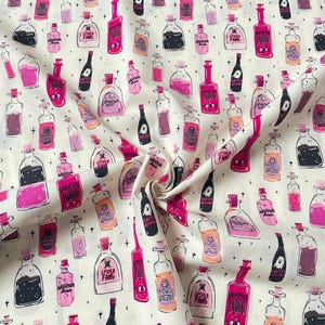 Può includere: Tessuto bianco sporco con un motivo ripetuto di bottiglie di pozioni in varie dimensioni e tonalità di rosa, nero e arancione. Le bottiglie hanno tappi ed etichette con testo come "Vampire Blood" e "Spider Fang". Piccole croci e stelle nere sono sparse.