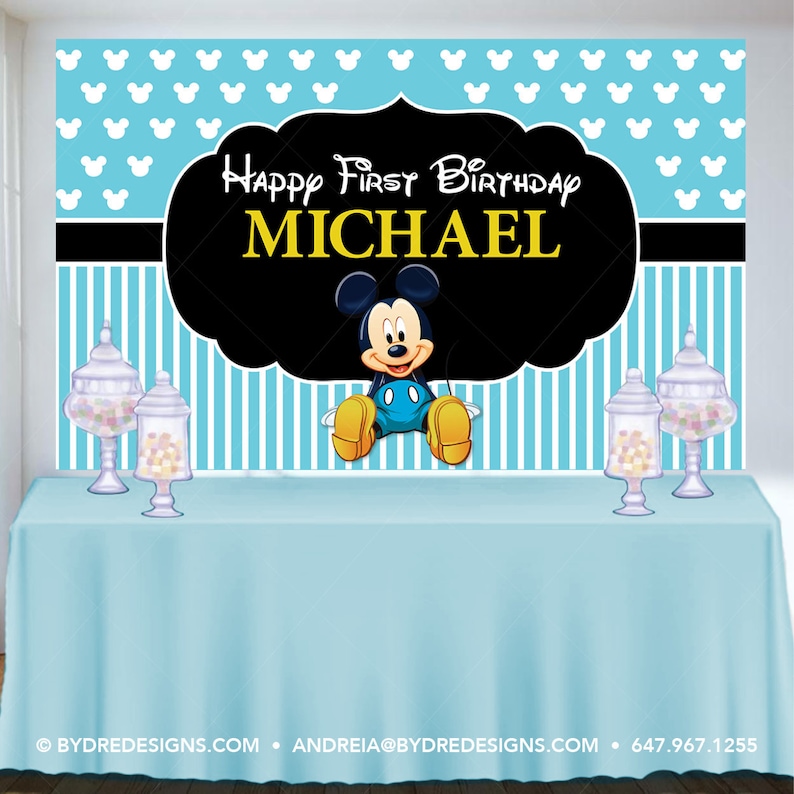 K&ouml;nnte beinhalten: Geburtstags-Hintergrund mit Micky Maus. Der Hintergrund hat einen hellblauen Hintergrund mit wei&szlig;en Micky-Maus-Silhouetten. Der Text "Happy First Birthday MICHAEL" wird auf einem schwarzen, wolkenf&ouml;rmigen Design angezeigt. Eine hellblaue Tischdecke befindet sich im Vordergrund.