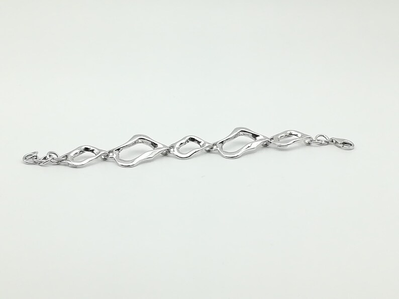 Asymetrical silver bracelet large and small link .