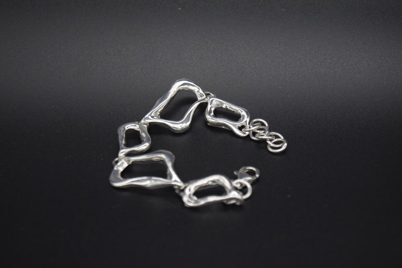 Asymetrical silver bracelet large and small link .