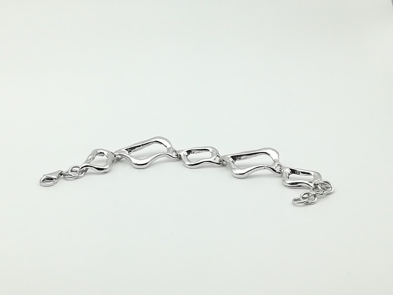 Asymetrical silver bracelet large and small link .
